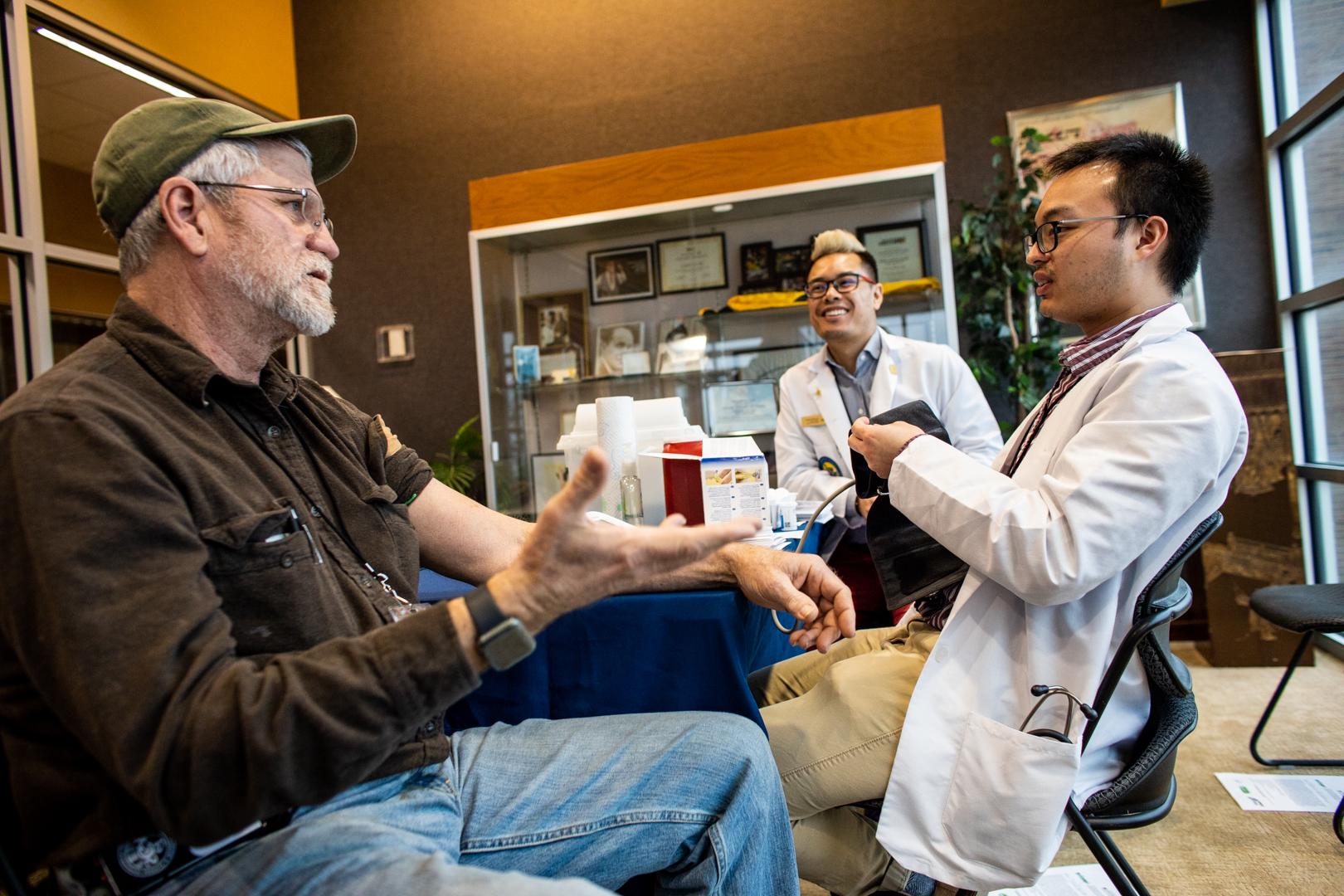 Pharmacy students working with farmer